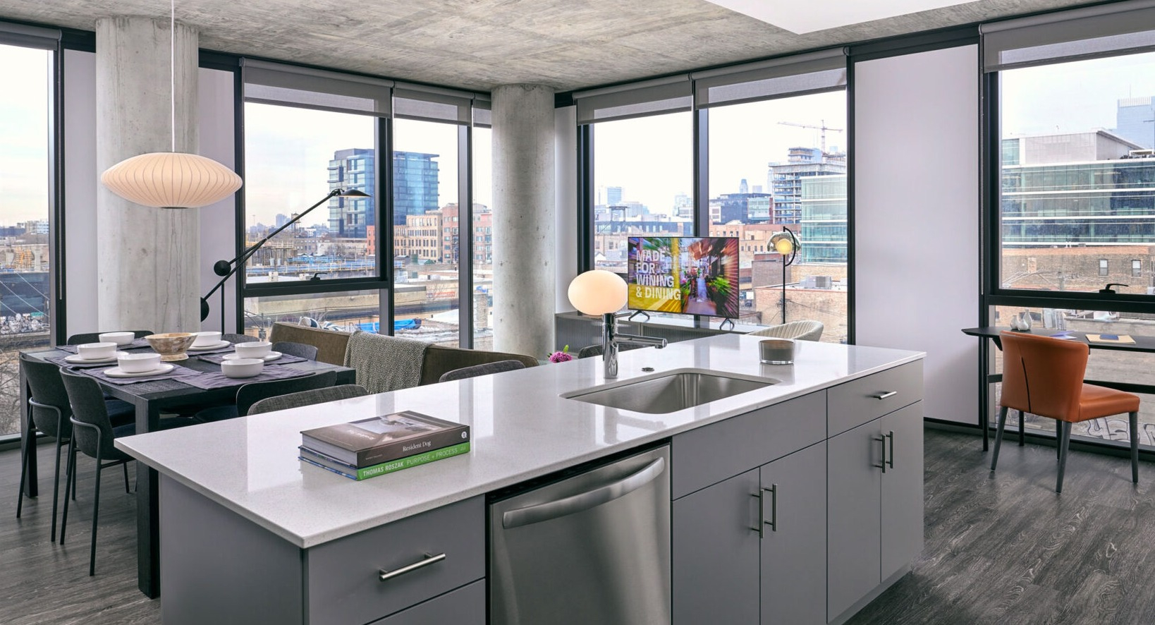 Modern open-concept kitchen and living room at Fulbrix Apartments in Chicago, featuring a large island, dining area, and city views