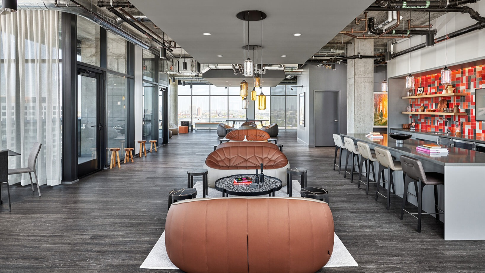 Expansive resident lounge and bar area at Fulbrix Apartments in Chicago, with various seating options, modern decor, and city views