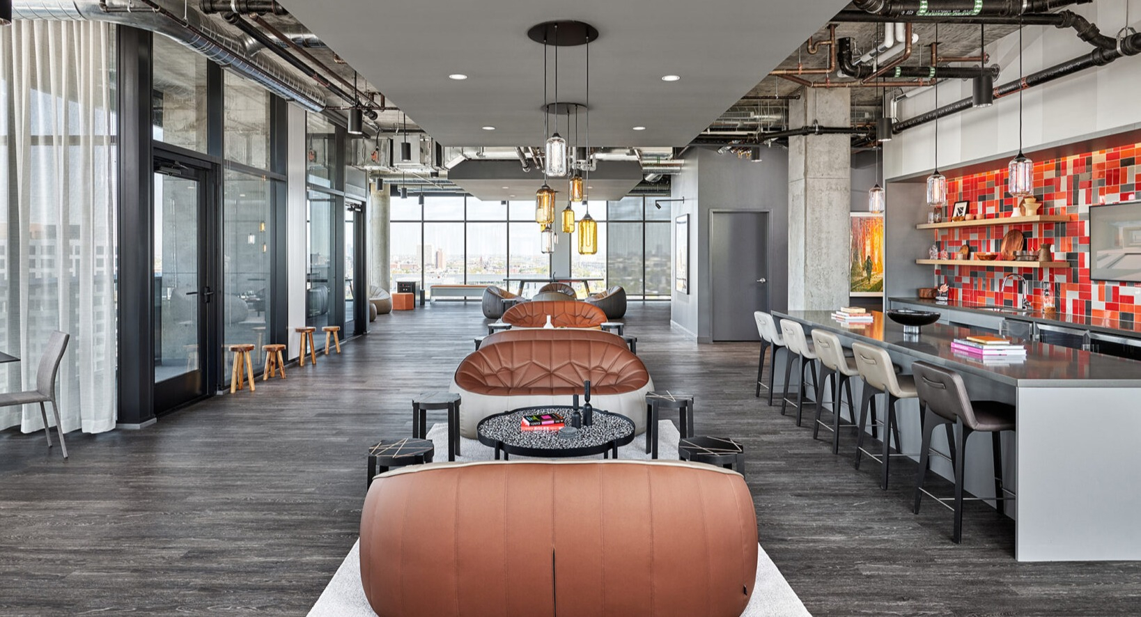 Expansive resident lounge and bar area at Fulbrix Apartments in Chicago, with various seating options, modern decor, and city views
