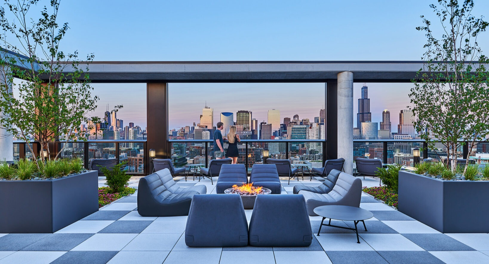 Expansive rooftop terrace at Fulbrix Apartments in Chicago, with stylish seating areas, lush greenery, and stunning panoramic city views