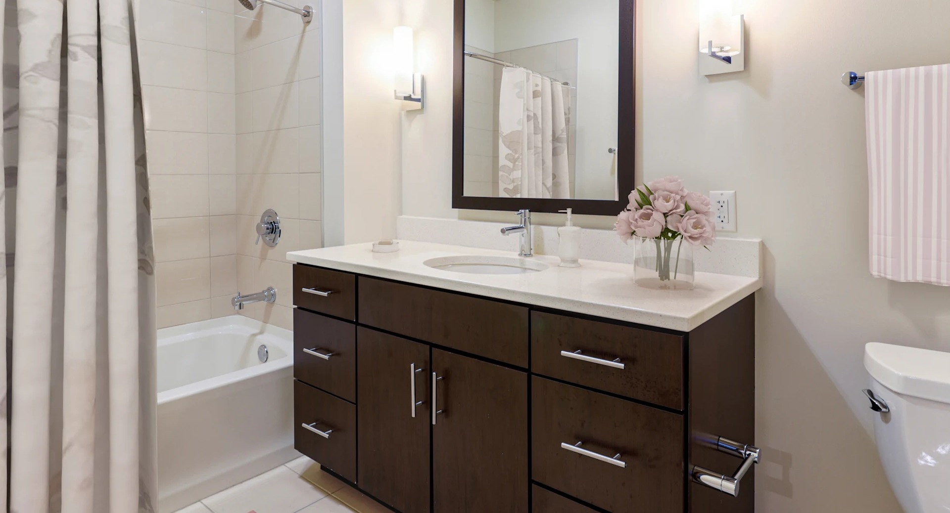 Modern bathroom with a stylish vanity, large mirror, and a shower-tub combination at Gateway West Loop apartments in Chicago