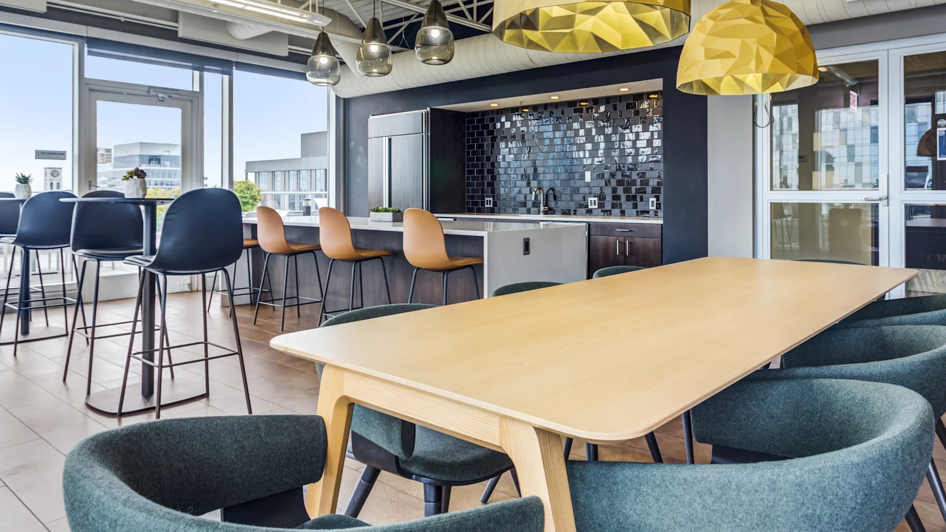 Spacious community kitchen and dining area with modern appliances and stylish lighting at Gateway West Loop apartments in Chicago