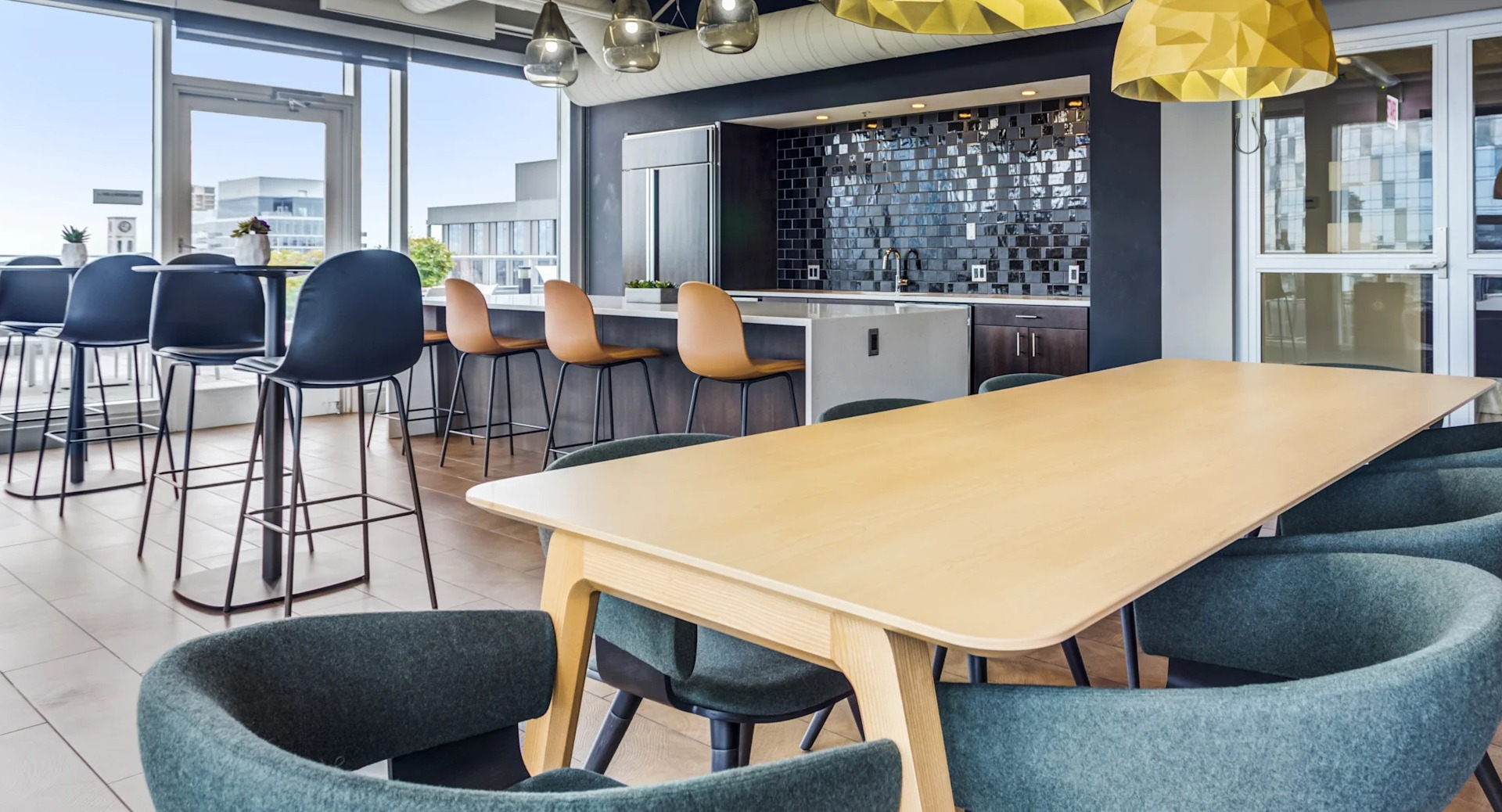 Spacious community kitchen and dining area with modern appliances and stylish lighting at Gateway West Loop apartments in Chicago