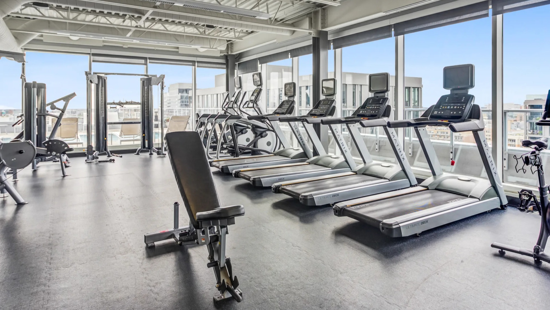 State-of-the-art fitness center featuring cardio machines and city views at Gateway West Loop apartments in Chicago