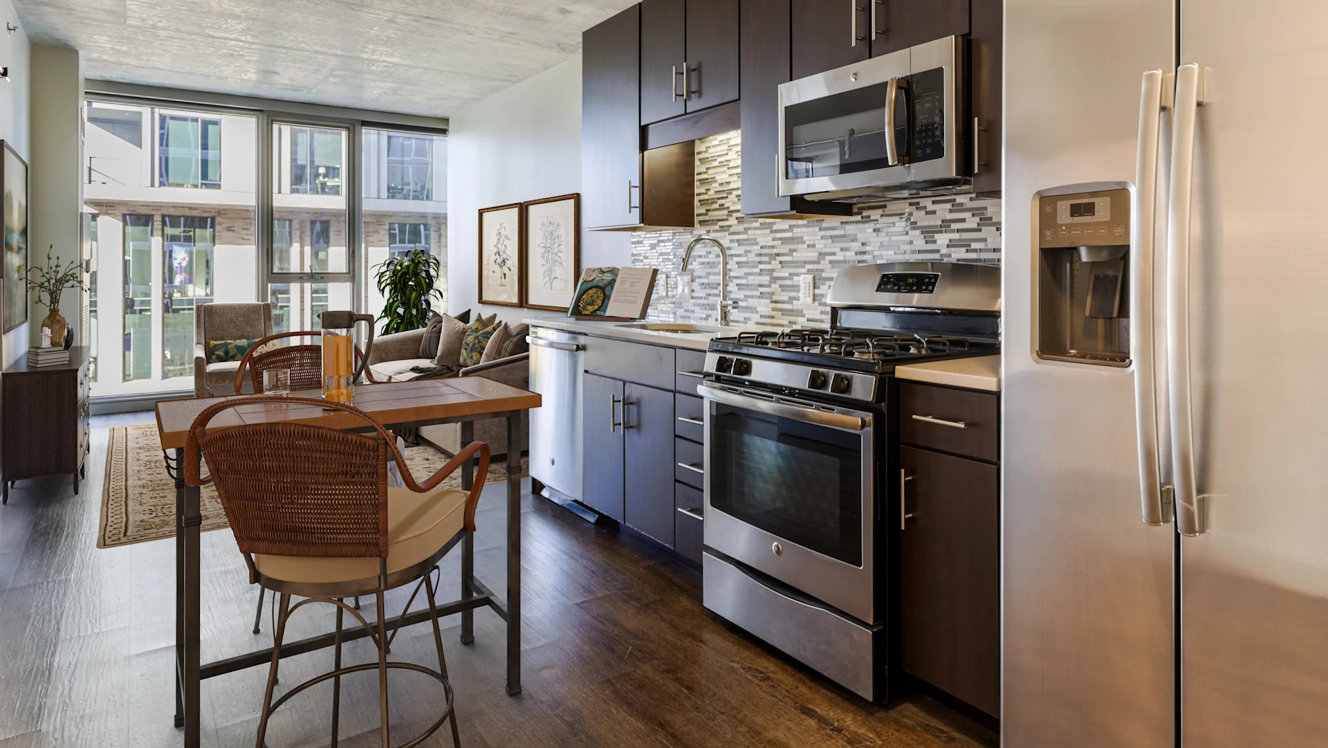 Open-concept kitchen and dining area featuring stainless steel appliances and city views at Gateway West Loop apartments in Chicago