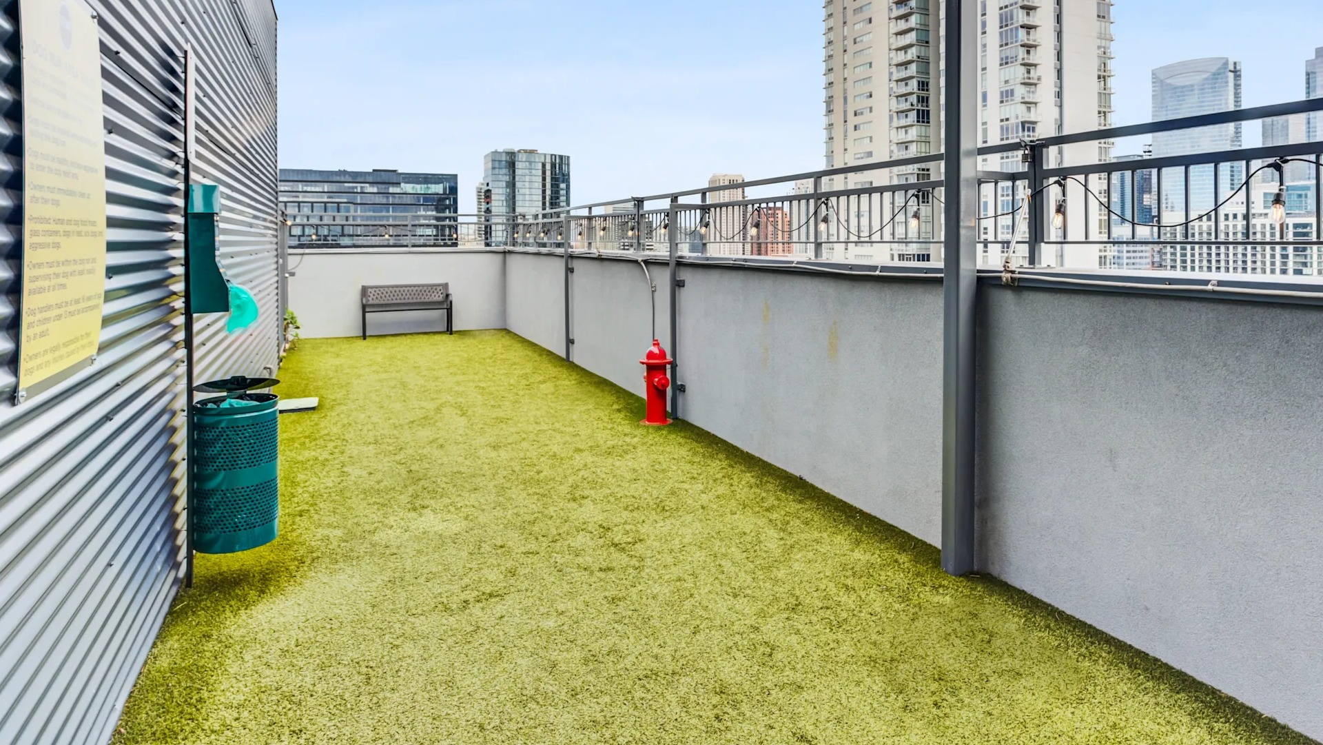 Outdoor pet-friendly dog run with artificial turf and city views, perfect for pets at Gateway West Loop in Chicago