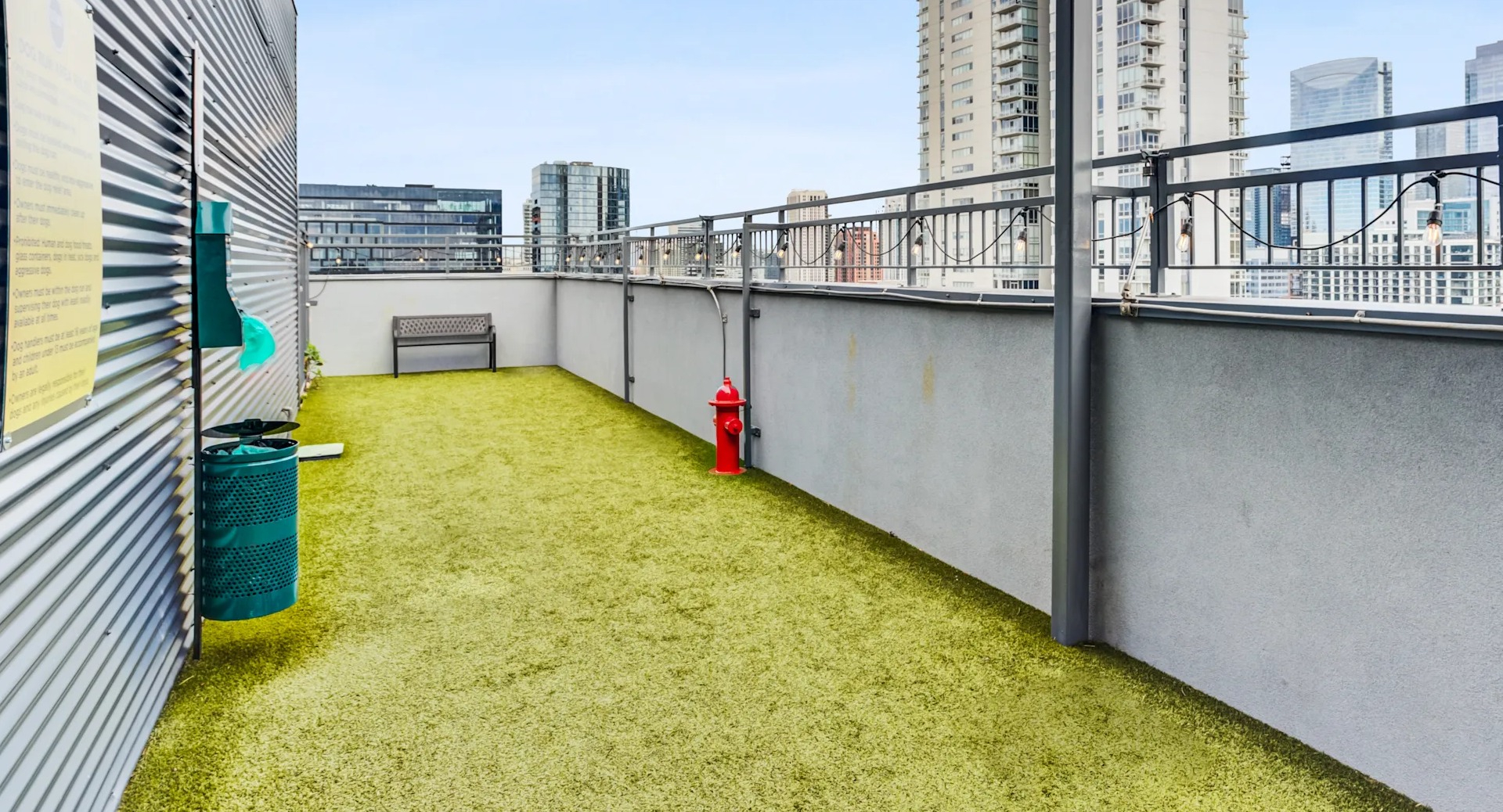 Outdoor pet-friendly dog run with artificial turf and city views, perfect for pets at Gateway West Loop in Chicago