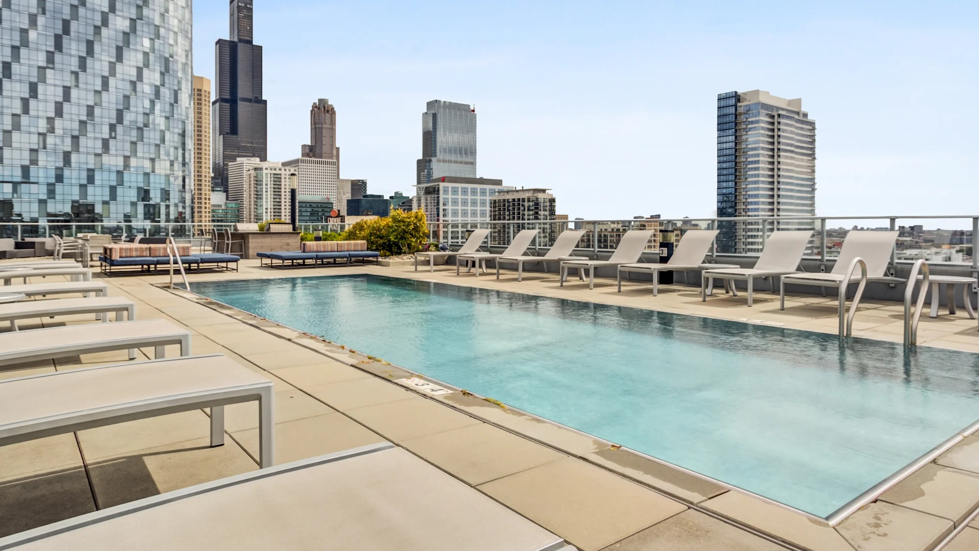 Inviting pool deck with lounge seating and breathtaking city skyline views at Gateway West Loop apartments in Chicago
