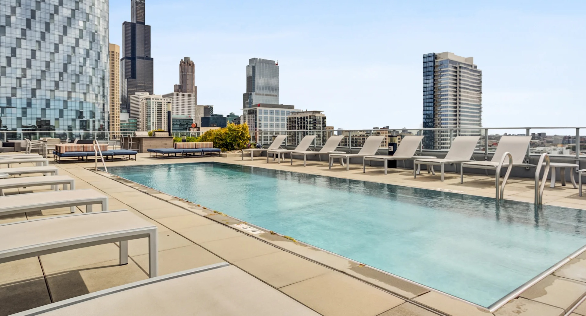 Inviting pool deck with lounge seating and breathtaking city skyline views at Gateway West Loop apartments in Chicago