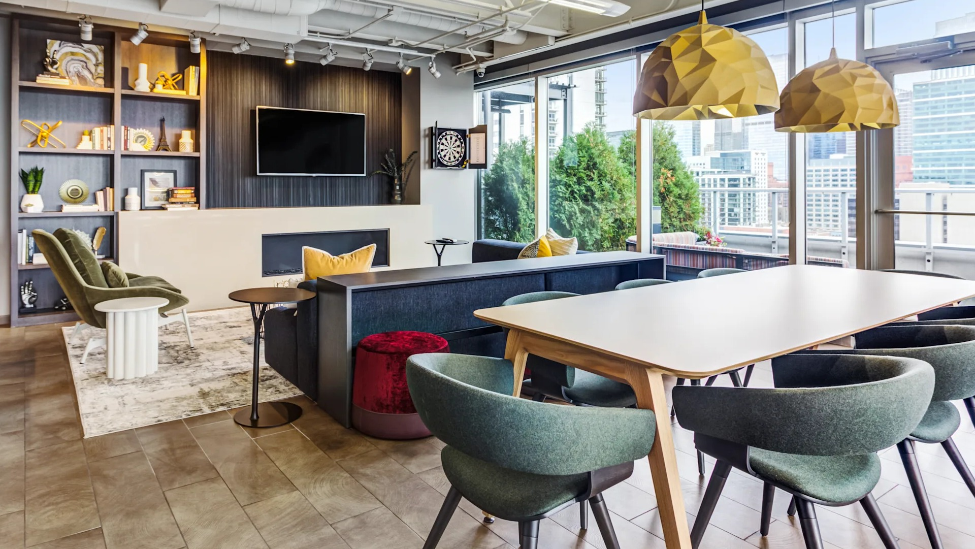 Modern resident lounge with ample seating, a large TV, dartboard, and city views at Gateway West Loop apartments in Chicago