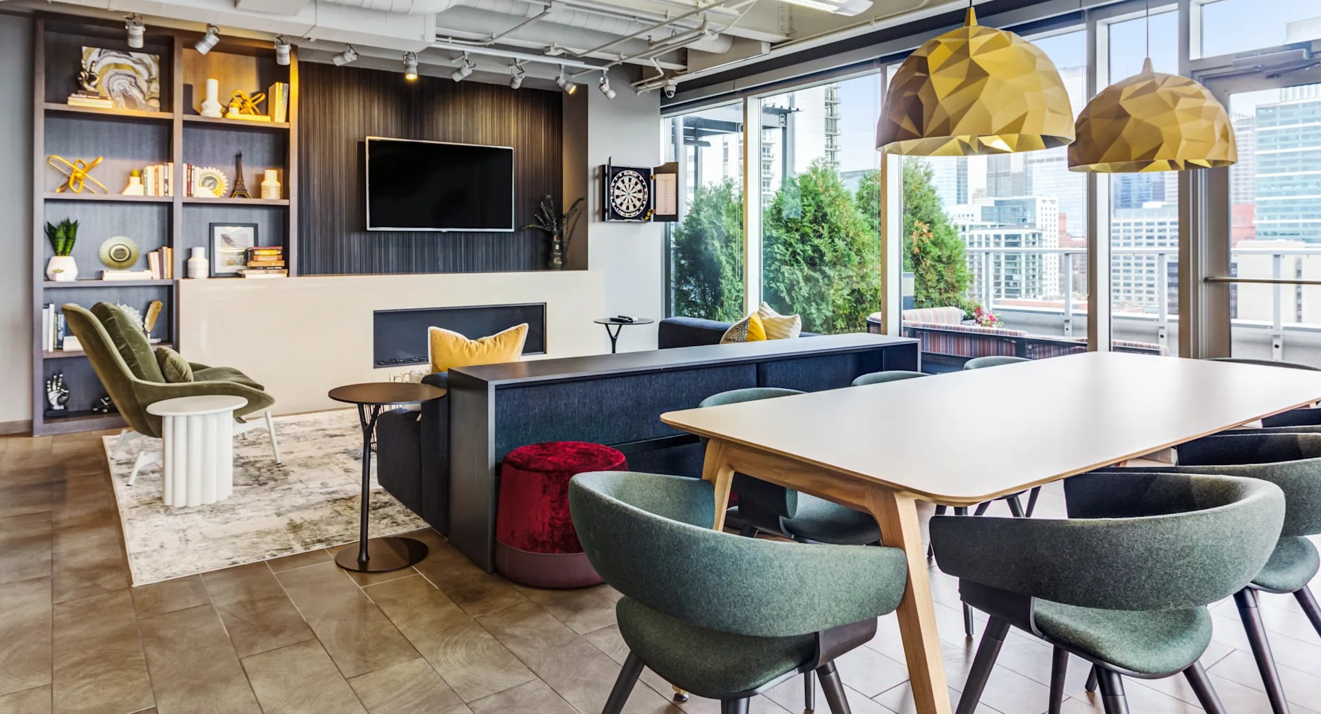 Modern resident lounge with ample seating, a large TV, dartboard, and city views at Gateway West Loop apartments in Chicago