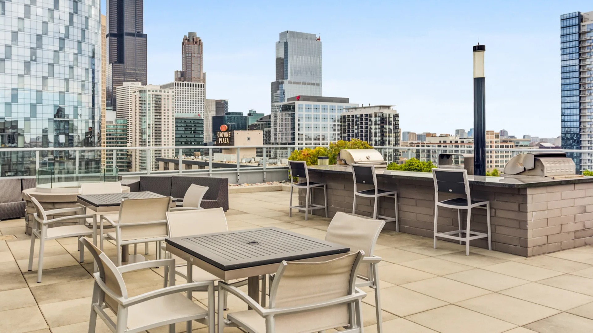 Expansive rooftop deck with outdoor seating, grilling stations, and stunning Chicago city skyline views at Gateway West Loop