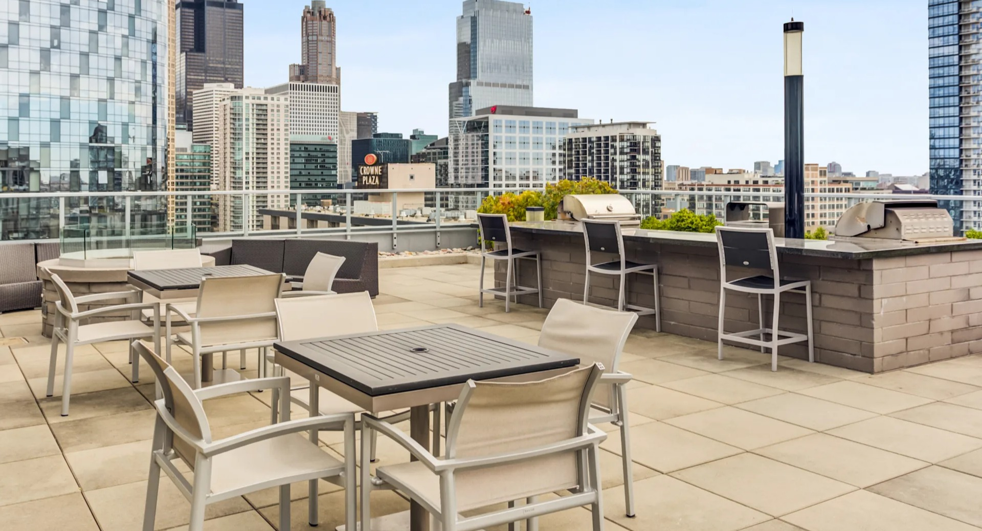 Expansive rooftop deck with outdoor seating, grilling stations, and stunning Chicago city skyline views at Gateway West Loop