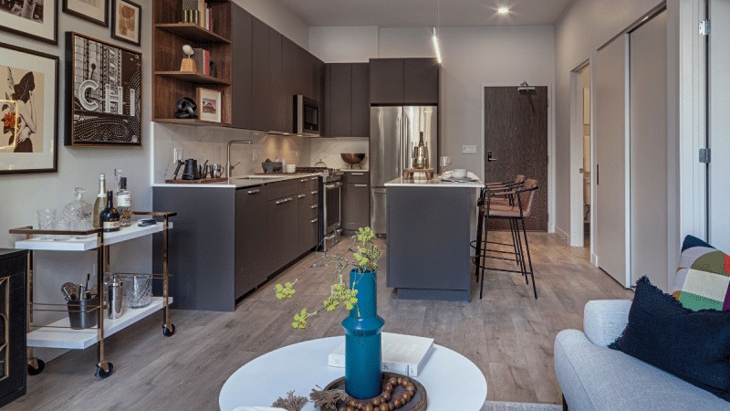 Modern open-concept kitchen and living room in an apartment unit at Gild, featuring stylish decor and finishes in Chicago