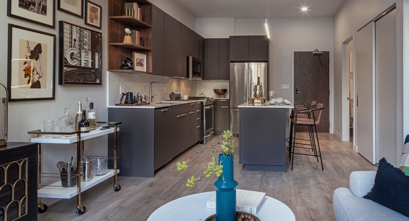 Modern open-concept kitchen and living room in an apartment unit at Gild, featuring stylish decor and finishes in Chicago