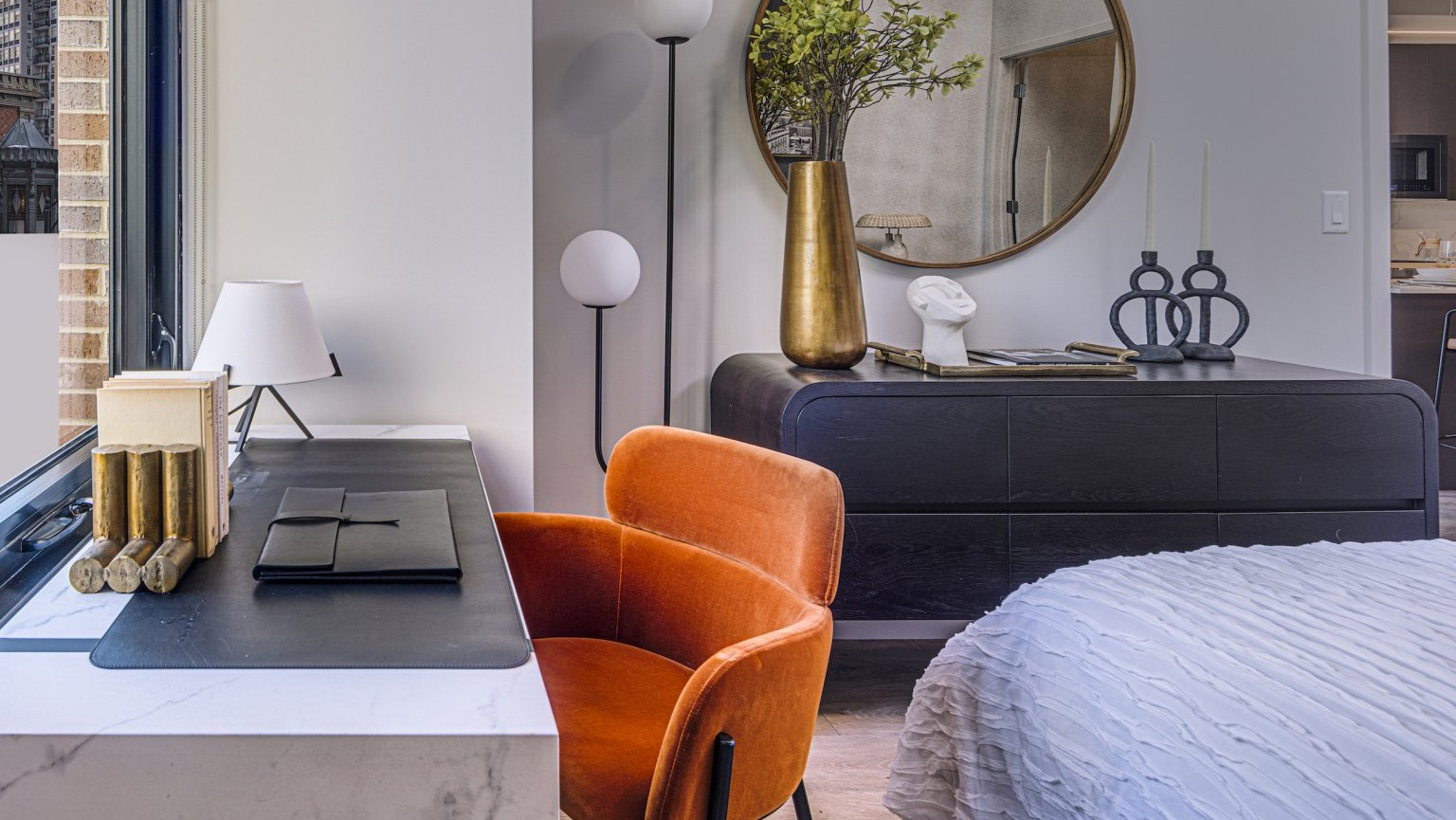 Stylish bedroom featuring a dedicated desk area by the window, perfect for work or study, at Gild apartments in Chicago