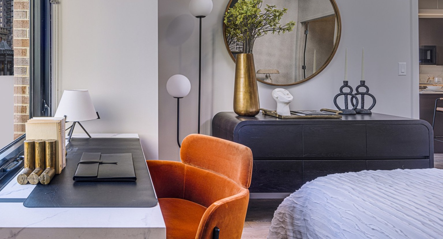 Stylish bedroom featuring a dedicated desk area by the window, perfect for work or study, at Gild apartments in Chicago
