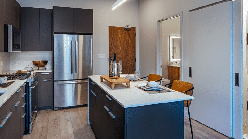 Modern kitchen with a large island and integrated laundry units, offering ultimate convenience at Gild apartments in Chicago