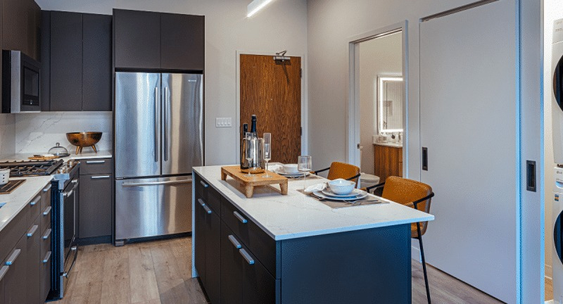 Modern kitchen with a large island and integrated laundry units, offering ultimate convenience at Gild apartments in Chicago