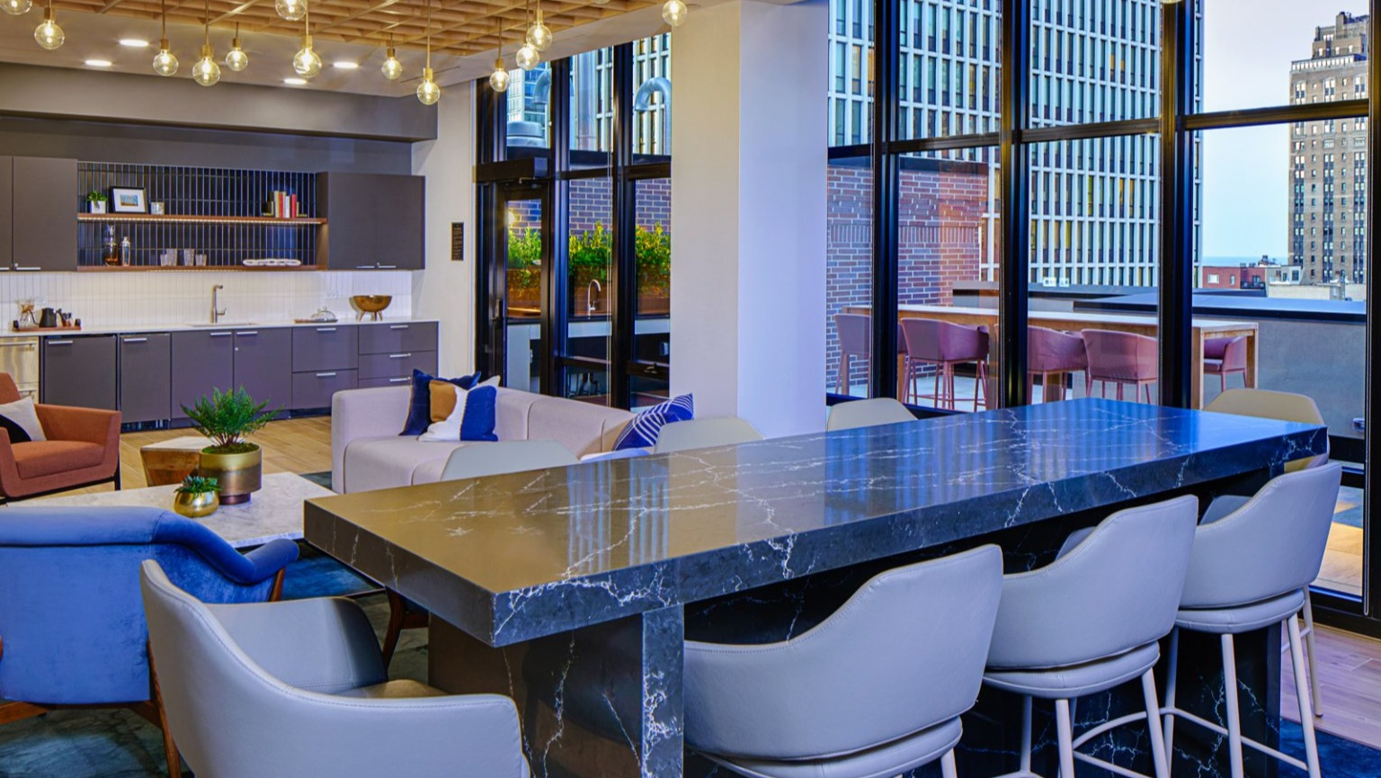 Elegant resident lounge with a fully equipped kitchenette, bar seating, and ample space for gatherings at Gild in Chicago