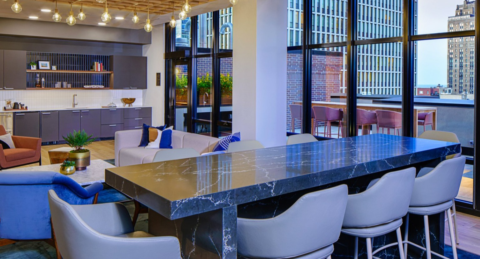 Elegant resident lounge with a fully equipped kitchenette, bar seating, and ample space for gatherings at Gild in Chicago