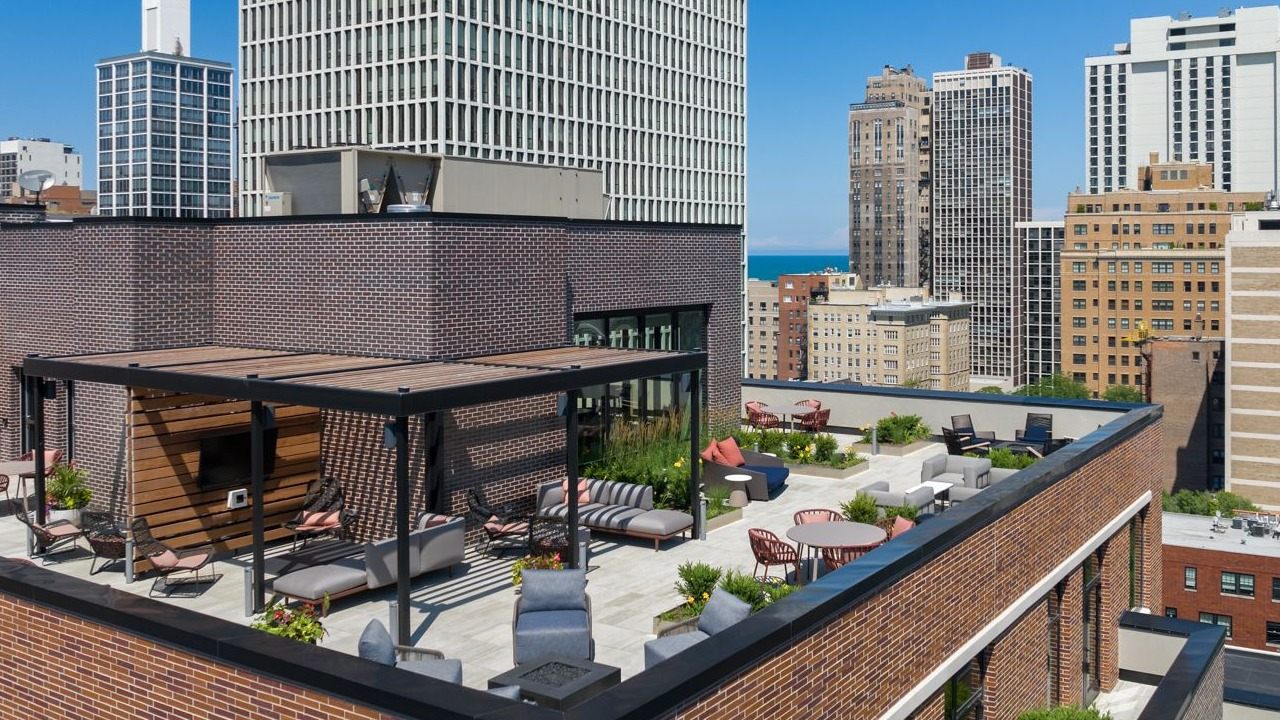 Aerial view of Gild's expansive rooftop with various lounge areas, city skyline, and distant lake views in Chicago
