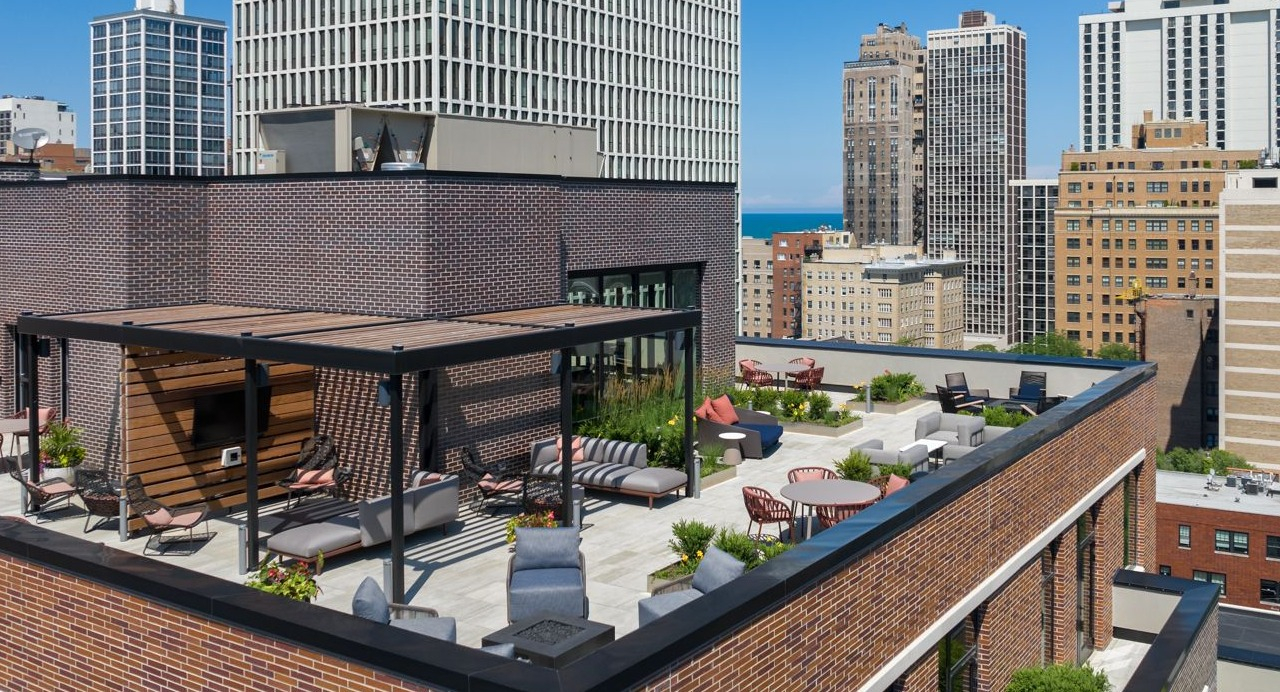 Aerial view of Gild's expansive rooftop with various lounge areas, city skyline, and distant lake views in Chicago