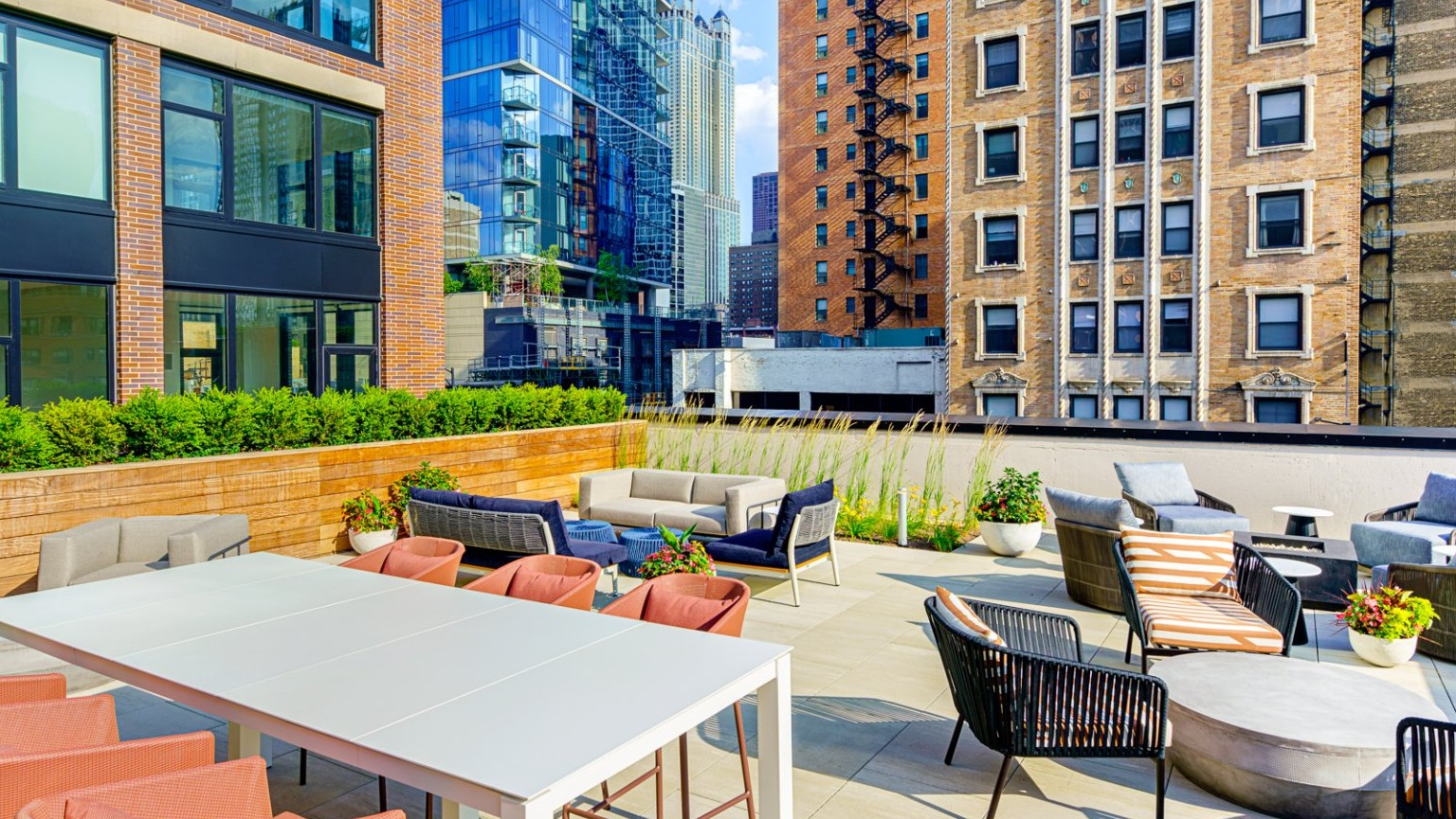 Spacious rooftop patio with various seating areas and impressive city views, perfect for relaxation at Gild apartments in Chicago