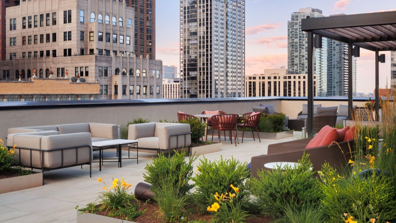 Beautifully landscaped rooftop terrace with outdoor seating areas and panoramic city views at Gild apartments in Chicago