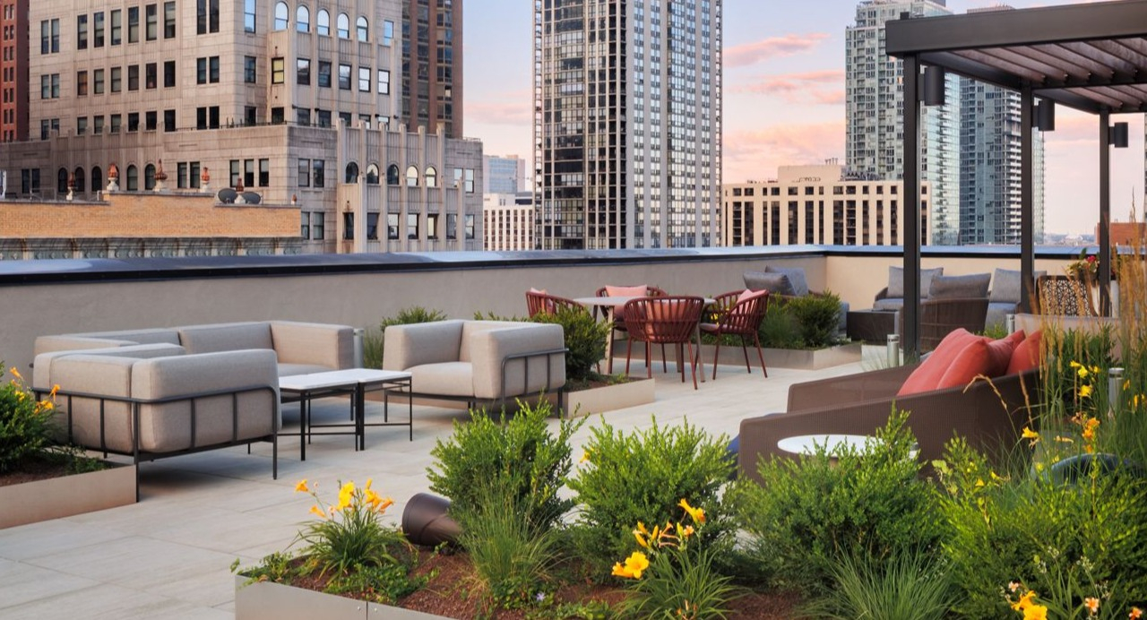Beautifully landscaped rooftop terrace with outdoor seating areas and panoramic city views at Gild apartments in Chicago