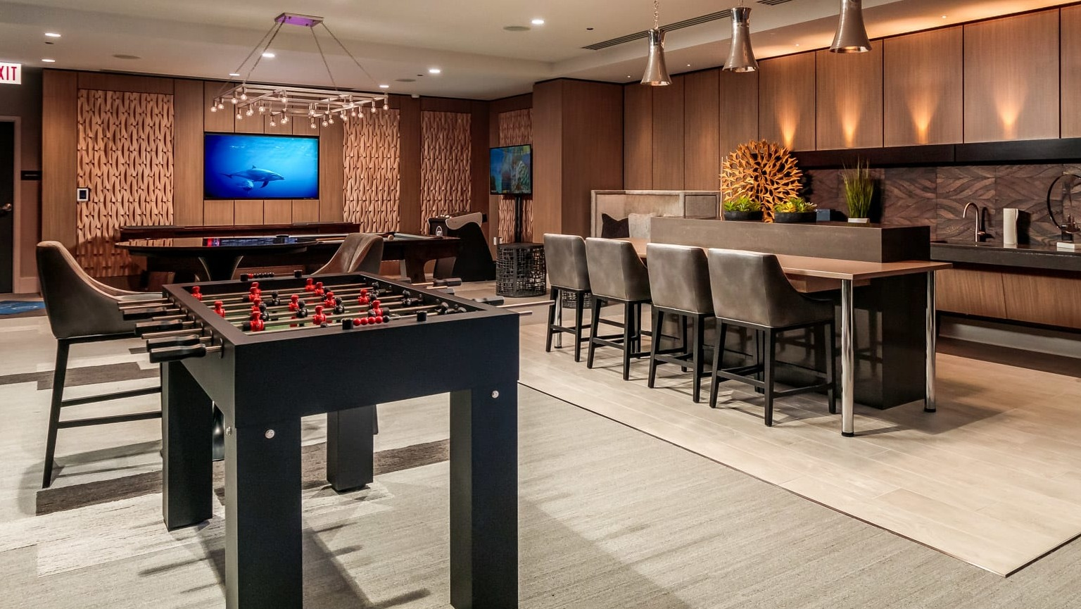 Lively game room at The Grand Central Apartments in Chicago, featuring foosball, billiards, and a modern kitchenette
