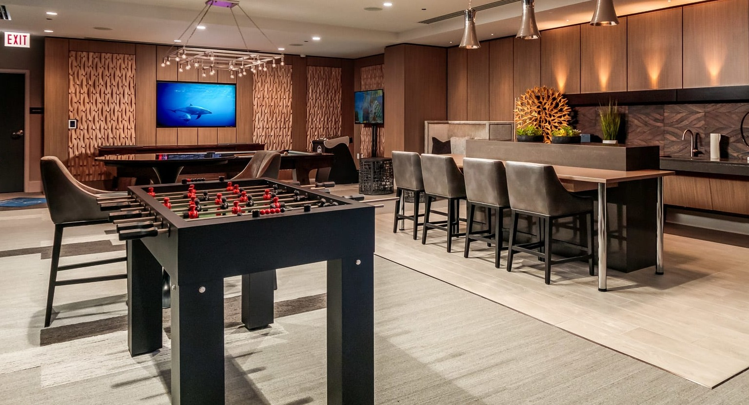 Lively game room at The Grand Central Apartments in Chicago, featuring foosball, billiards, and a modern kitchenette