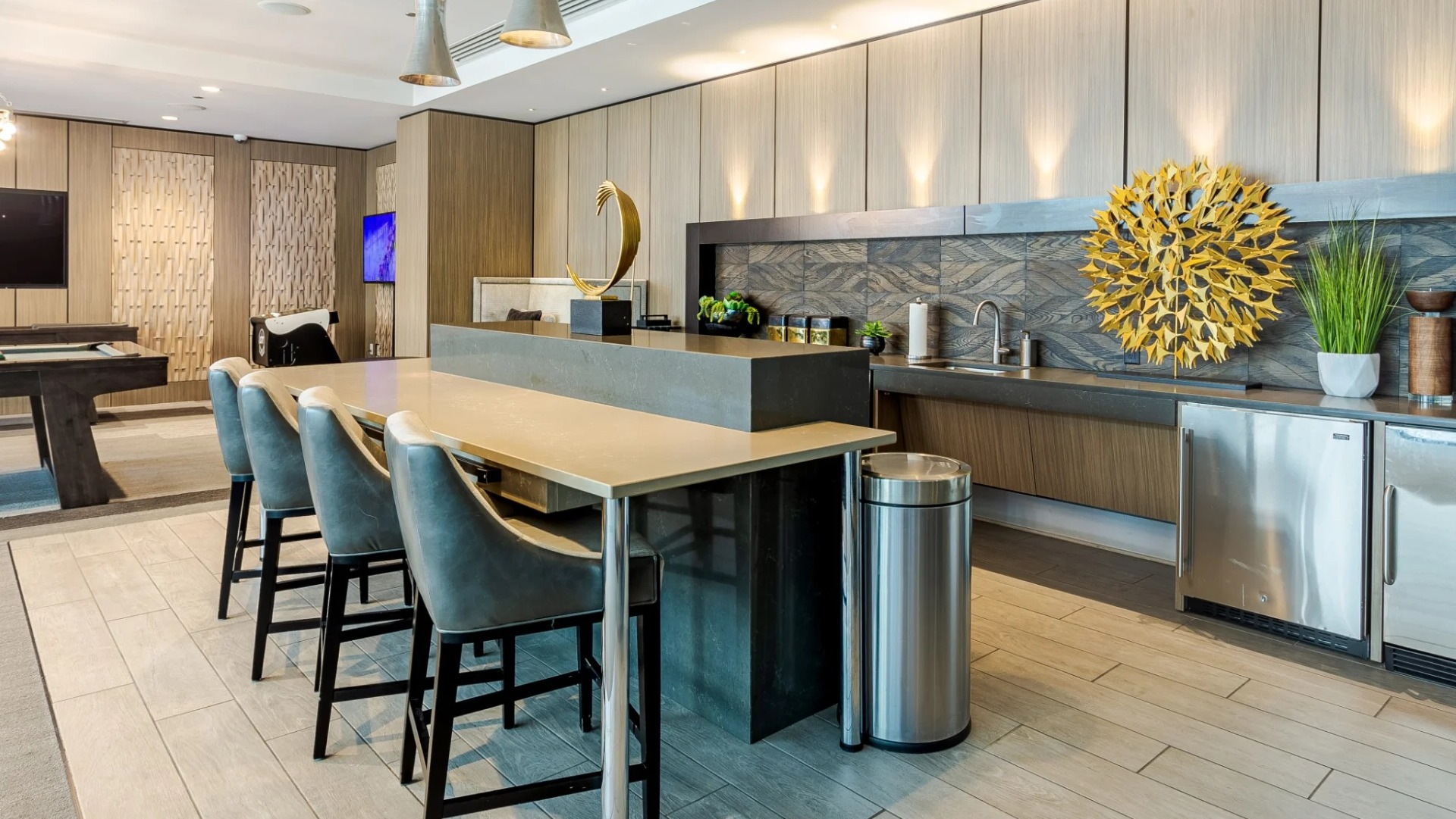 Modern game room at The Grand Central Apartments in Chicago, featuring a pool table, kitchenette, and ample seating