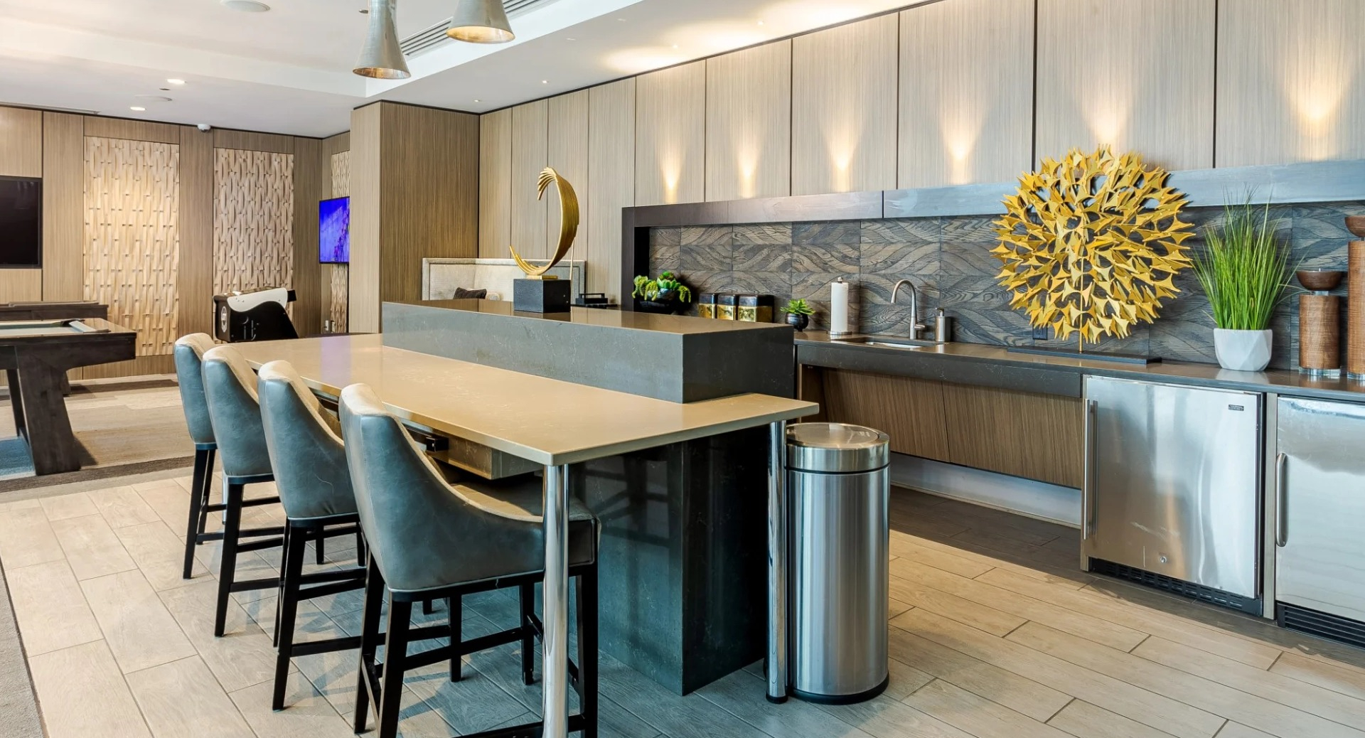 Modern game room at The Grand Central Apartments in Chicago, featuring a pool table, kitchenette, and ample seating