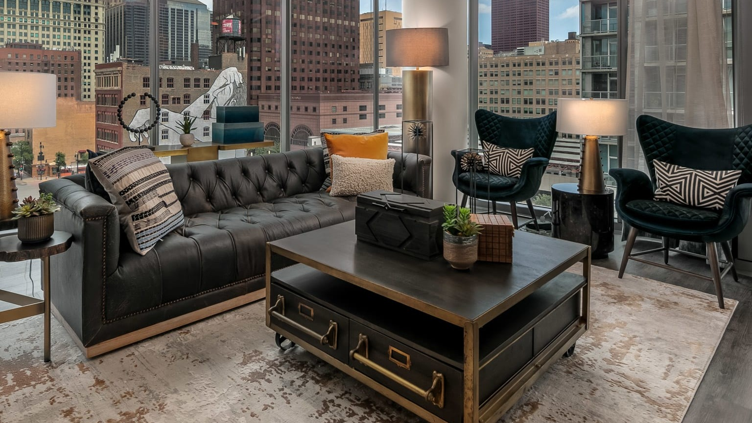 Luxurious apartment living room at The Grand Central Apartments in Chicago, featuring a black leather sofa and expansive city views