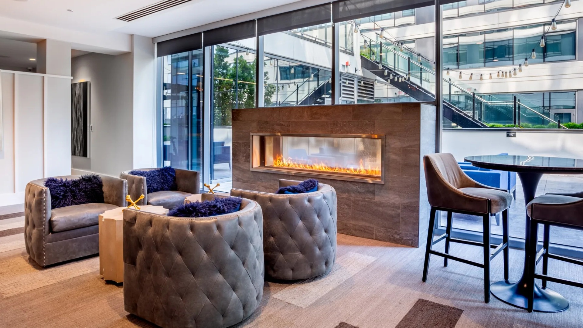 Cozy resident lounge at The Grand Central Apartments in Chicago, featuring a modern fireplace, stylish seating, and city views