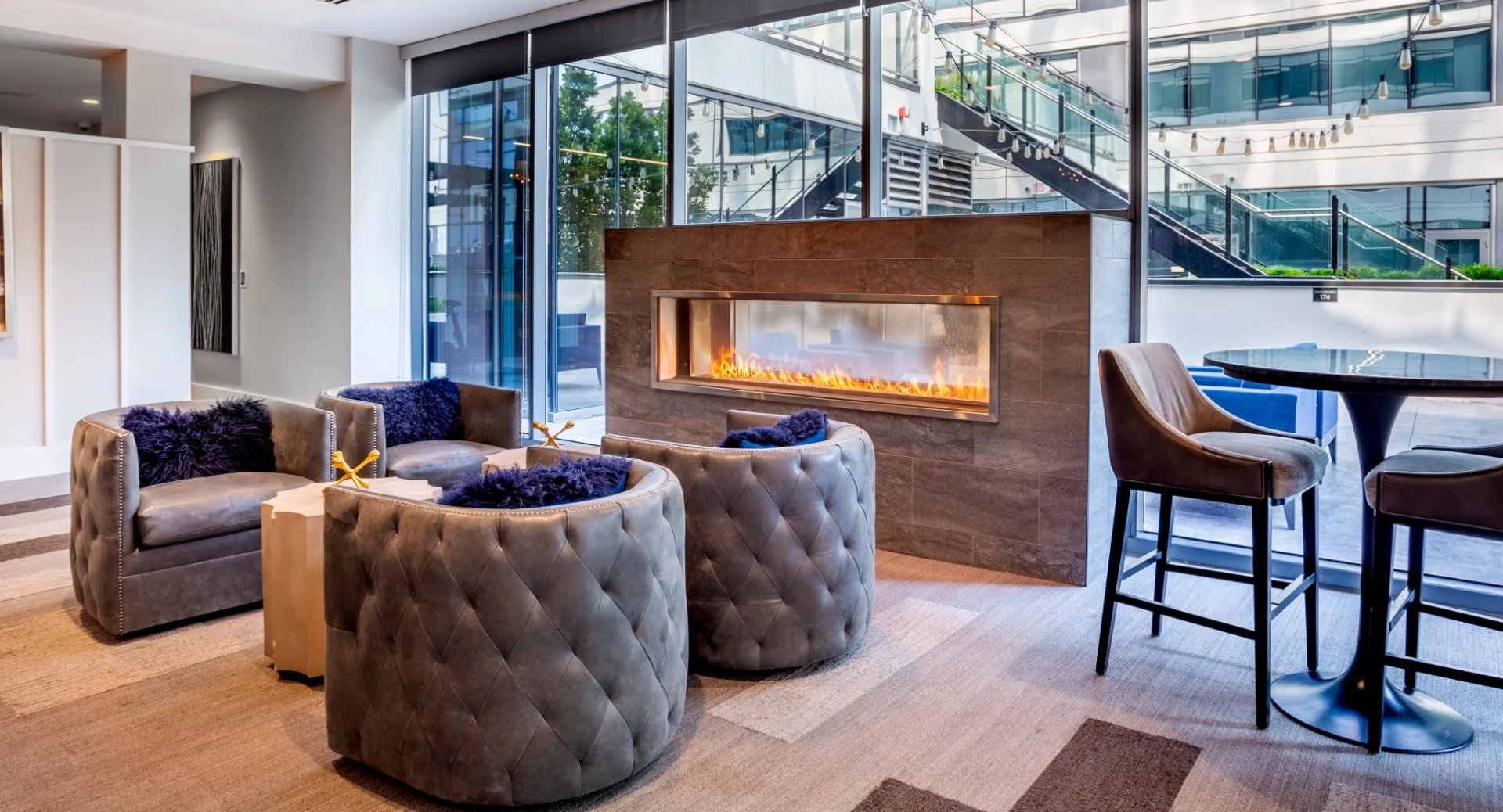 Cozy resident lounge at The Grand Central Apartments in Chicago, featuring a modern fireplace, stylish seating, and city views
