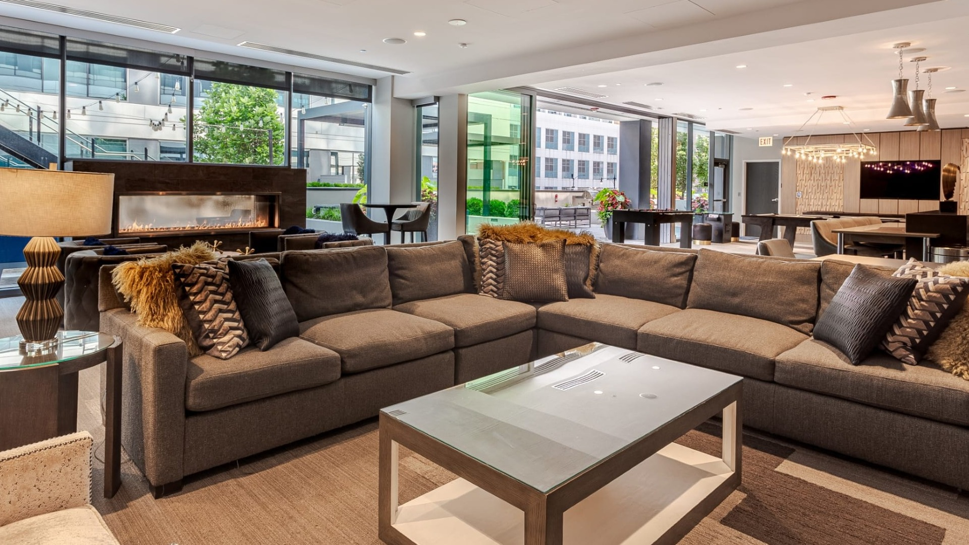 Spacious resident lounge at The Grand Central Apartments in Chicago, featuring a large sectional sofa, fireplace, and modern decor