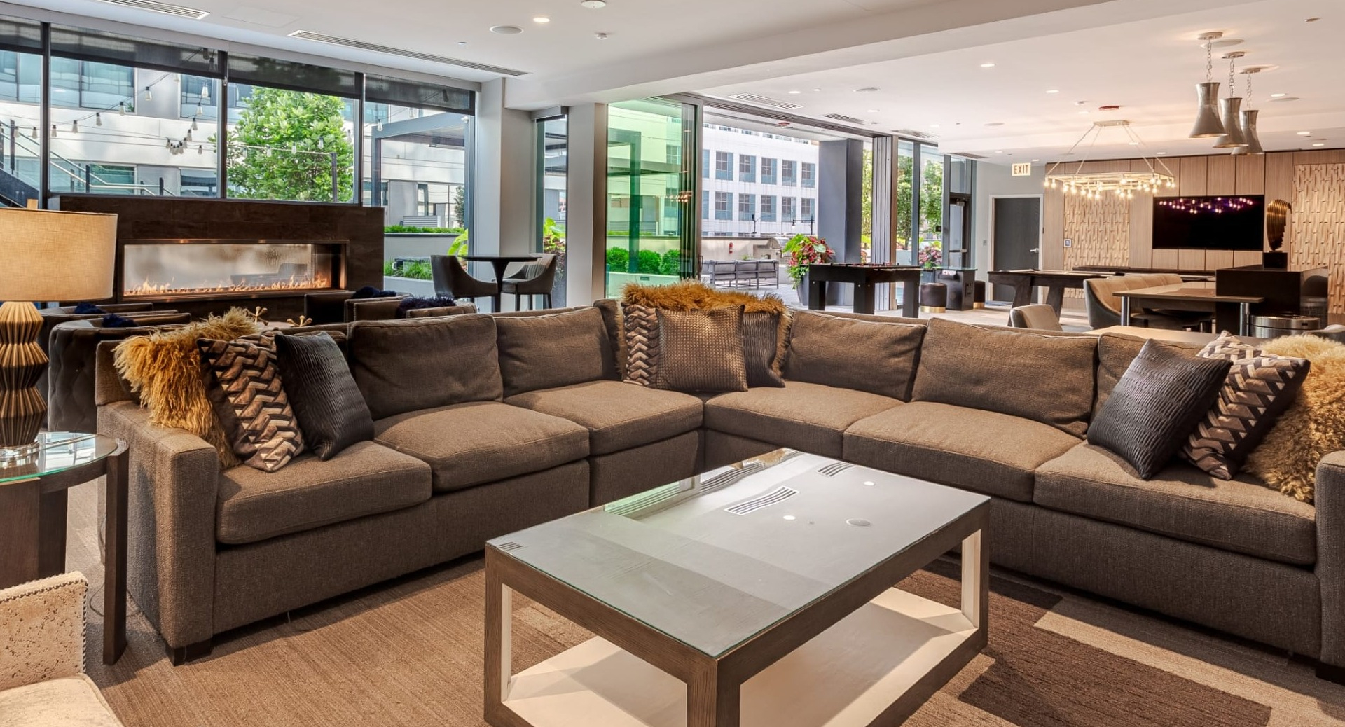 Spacious resident lounge at The Grand Central Apartments in Chicago, featuring a large sectional sofa, fireplace, and modern decor