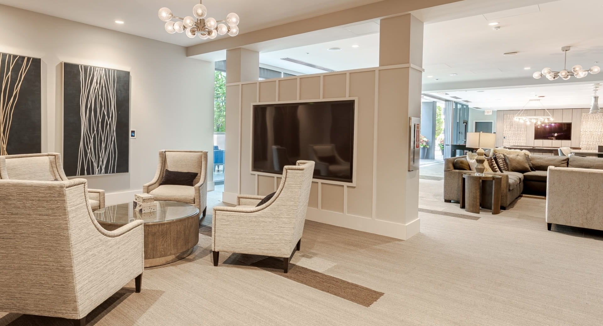 Sophisticated media lounge at The Grand Central Apartments in Chicago, featuring comfortable chairs and a large screen for entertainment