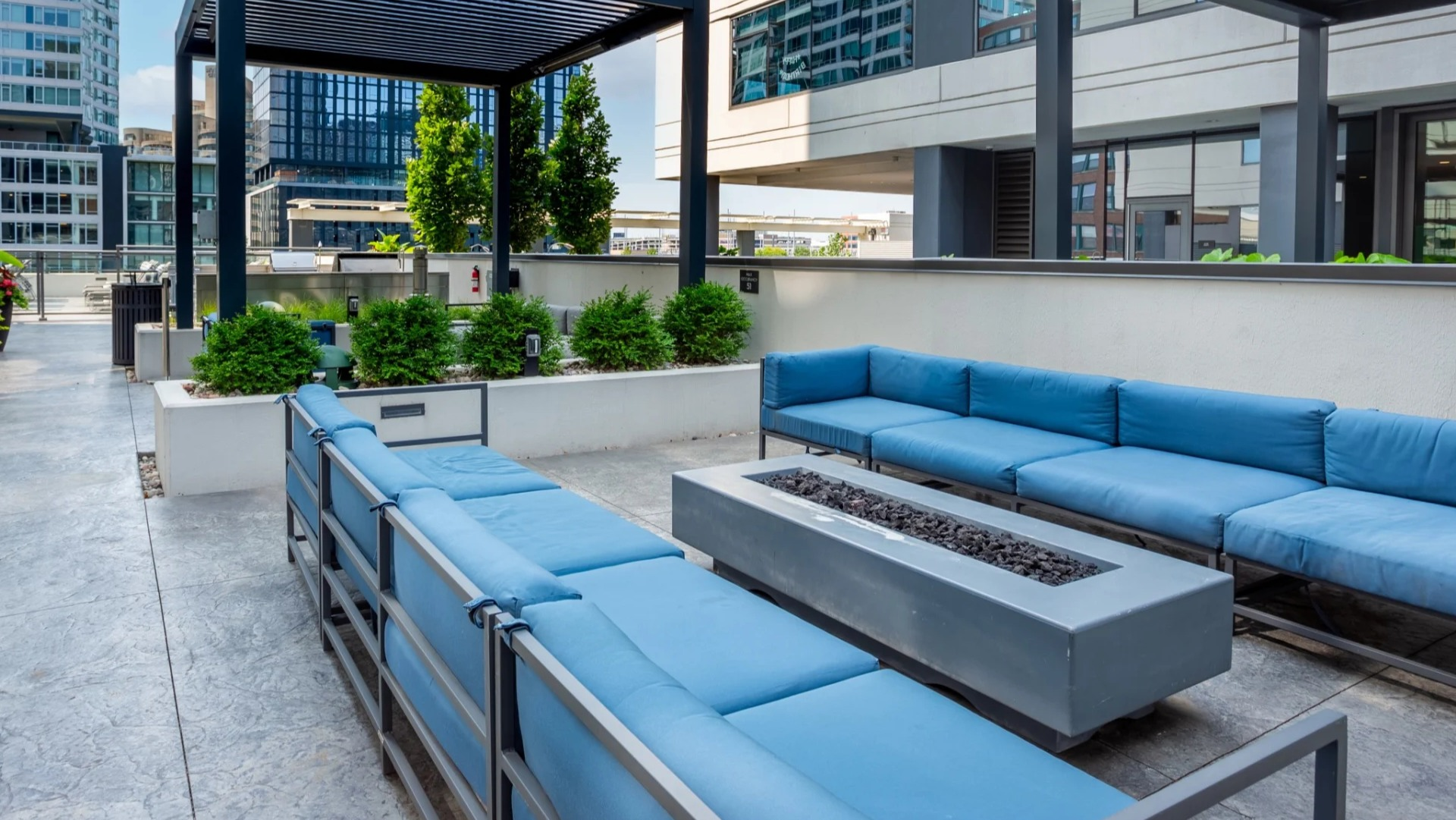 Modern outdoor patio at The Grand Central Apartments in Chicago, featuring comfortable blue sofas around a stylish fire pit