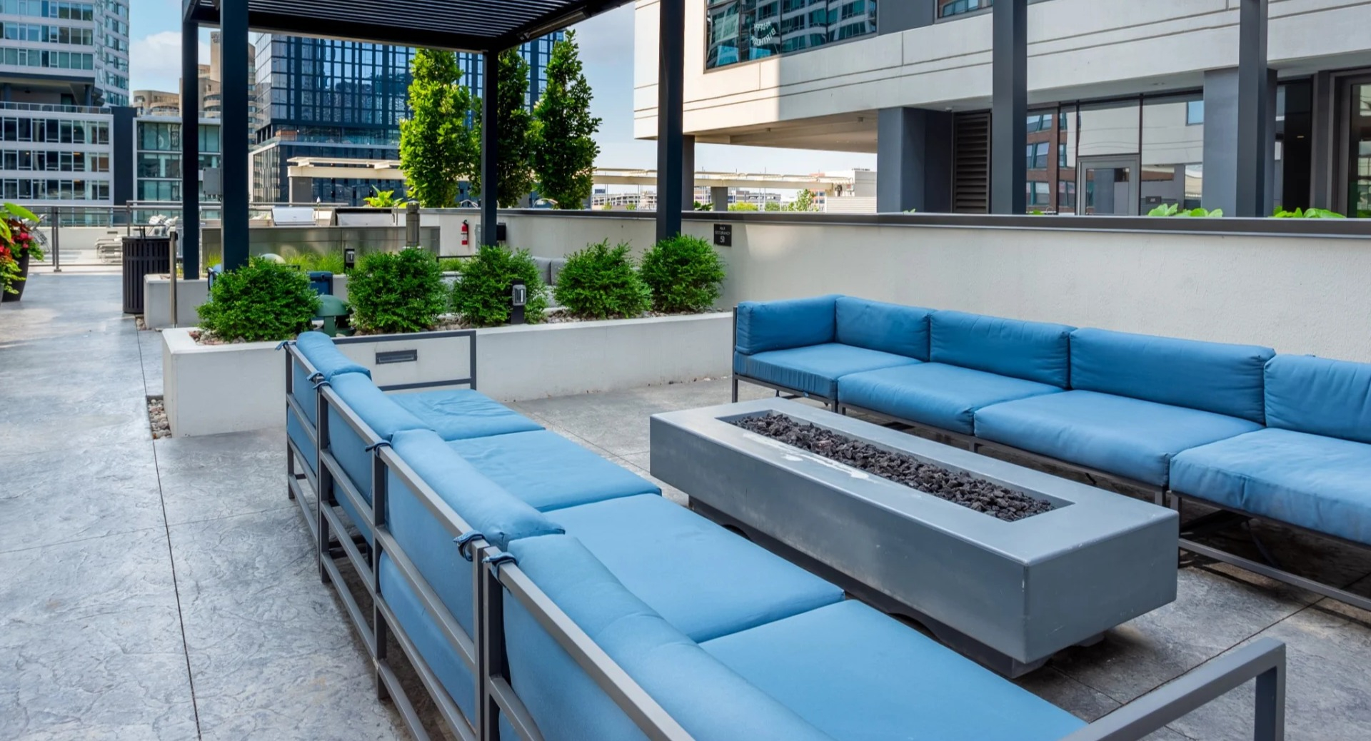 Modern outdoor patio at The Grand Central Apartments in Chicago, featuring comfortable blue sofas around a stylish fire pit