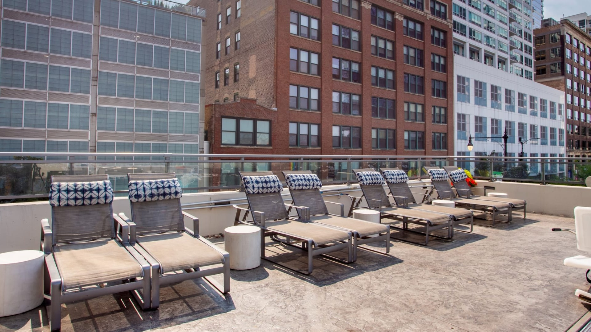 Relaxing poolside lounge area at The Grand Central Apartments in Chicago, featuring comfortable chairs for sunbathing