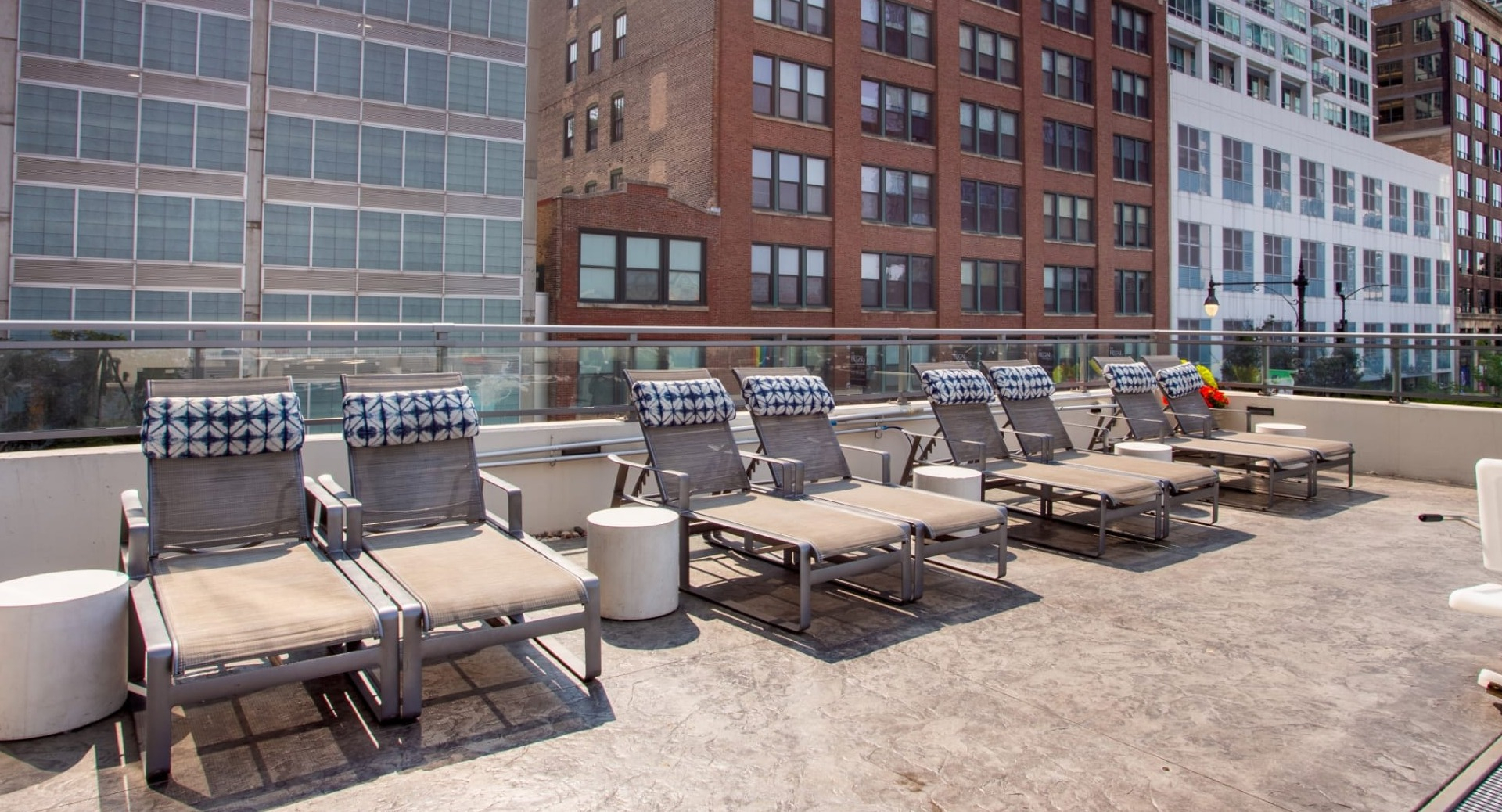 Relaxing poolside lounge area at The Grand Central Apartments in Chicago, featuring comfortable chairs for sunbathing
