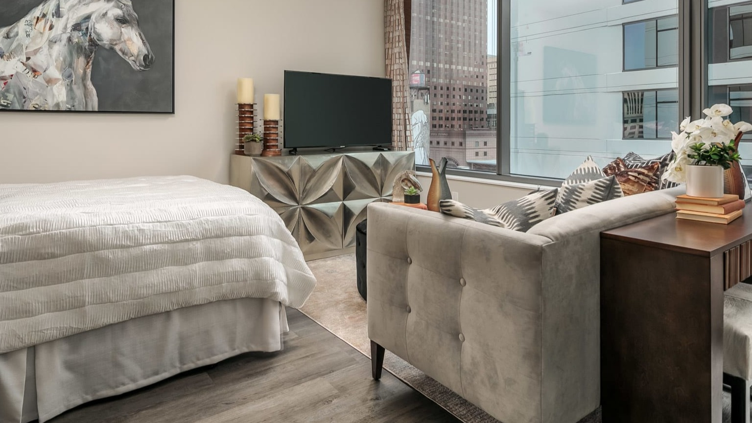 Modern studio apartment at The Grand Central Apartments in Chicago, featuring a comfortable bed, stylish decor, and city views