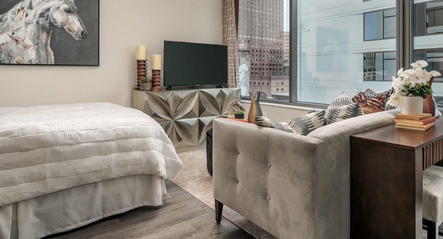 Modern studio apartment at The Grand Central Apartments in Chicago, featuring a comfortable bed, stylish decor, and city views