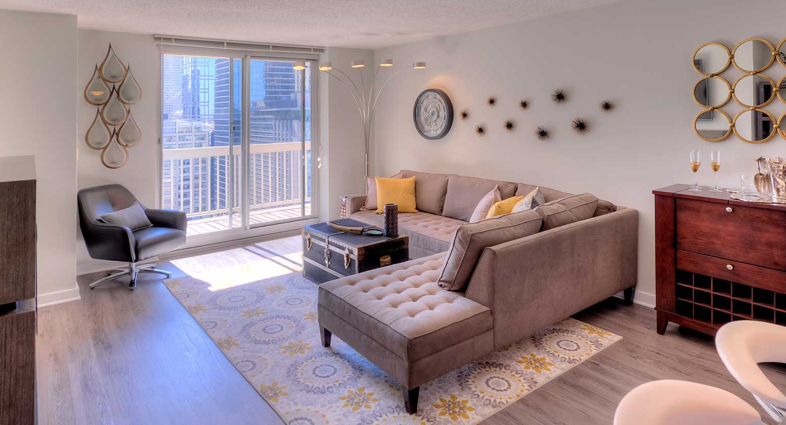Inviting living room with a comfortable sectional, stylish decor, and direct access to a private balcony at Grand Plaza, Chicago
