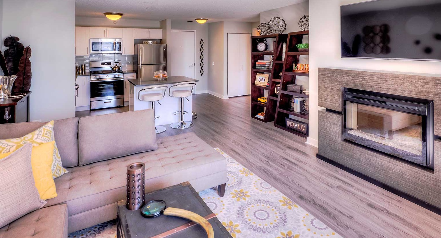 Open-concept living room and kitchen area featuring a modern fireplace and chic decor at Grand Plaza apartments in Chicago