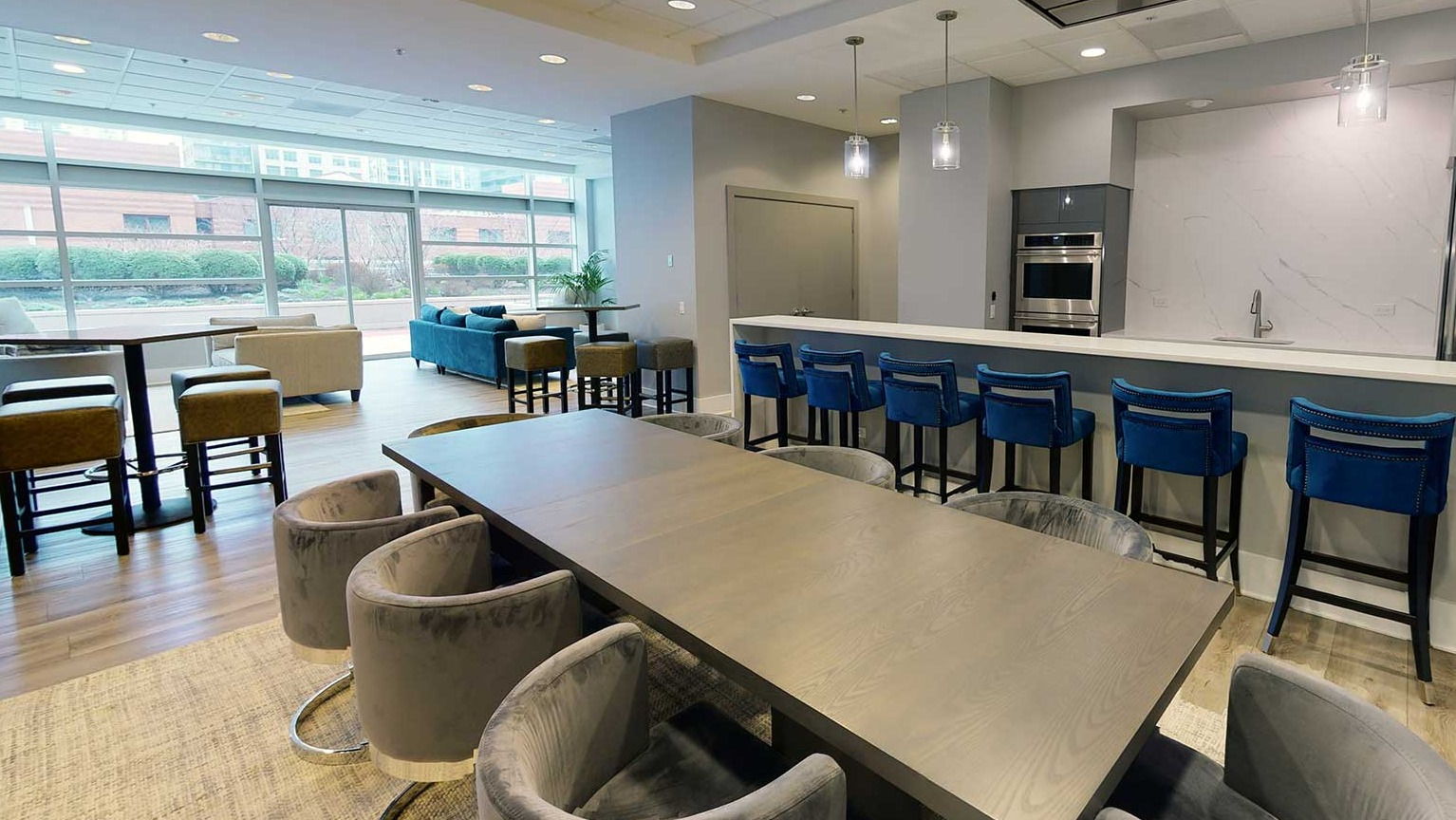 Expansive resident lounge with a large dining table, bar seating, and a modern kitchen for entertaining at Grand Plaza in Chicago