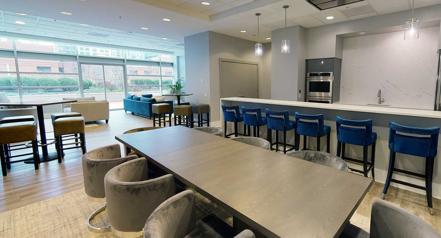 Expansive resident lounge with a large dining table, bar seating, and a modern kitchen for entertaining at Grand Plaza in Chicago